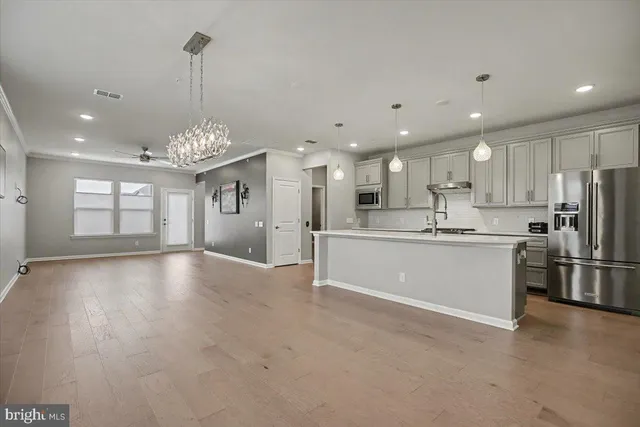 a view of large kitchen with stainless steel appliances granite countertop a sink a stove and a refrigerator