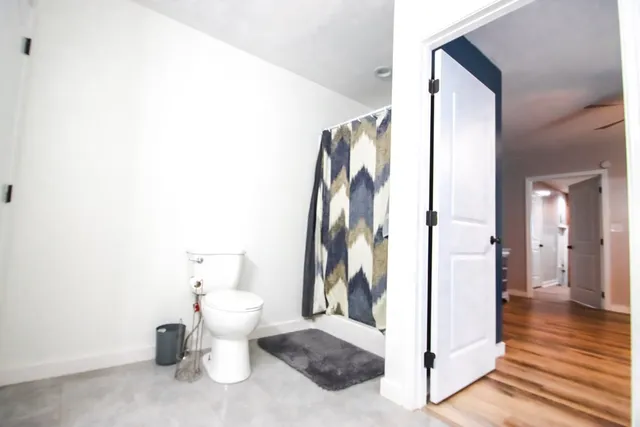 a bathroom with a toilet and a shower