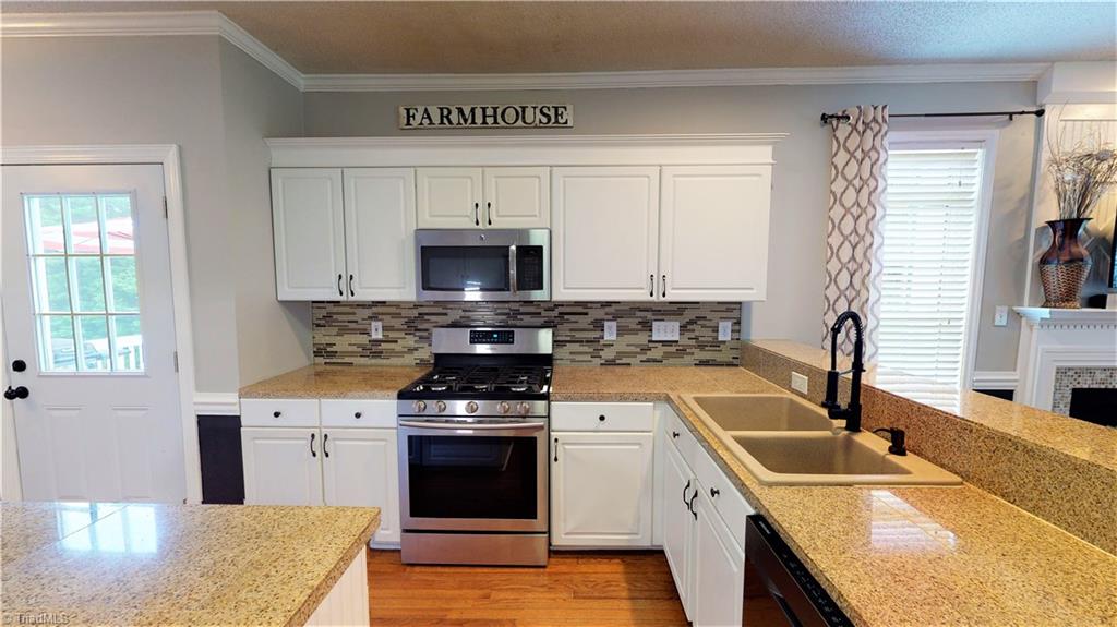 4129 Carroll Ridge Court High Point, NC 27265 - Photo 11 of 30 Cooks kitchen with stainless appliances, gas range (less than 1 year old), prep island, integrated sink with pull down sprayer on faucet.