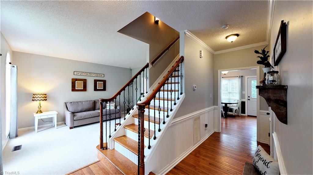 4129 Carroll Ridge Court High Point, NC 27265 - Photo 4 of 30 Staircase w/wrought-iron style railing and wood treads makes for a grand entrance! Updated color scheme gives a more modern appearance.