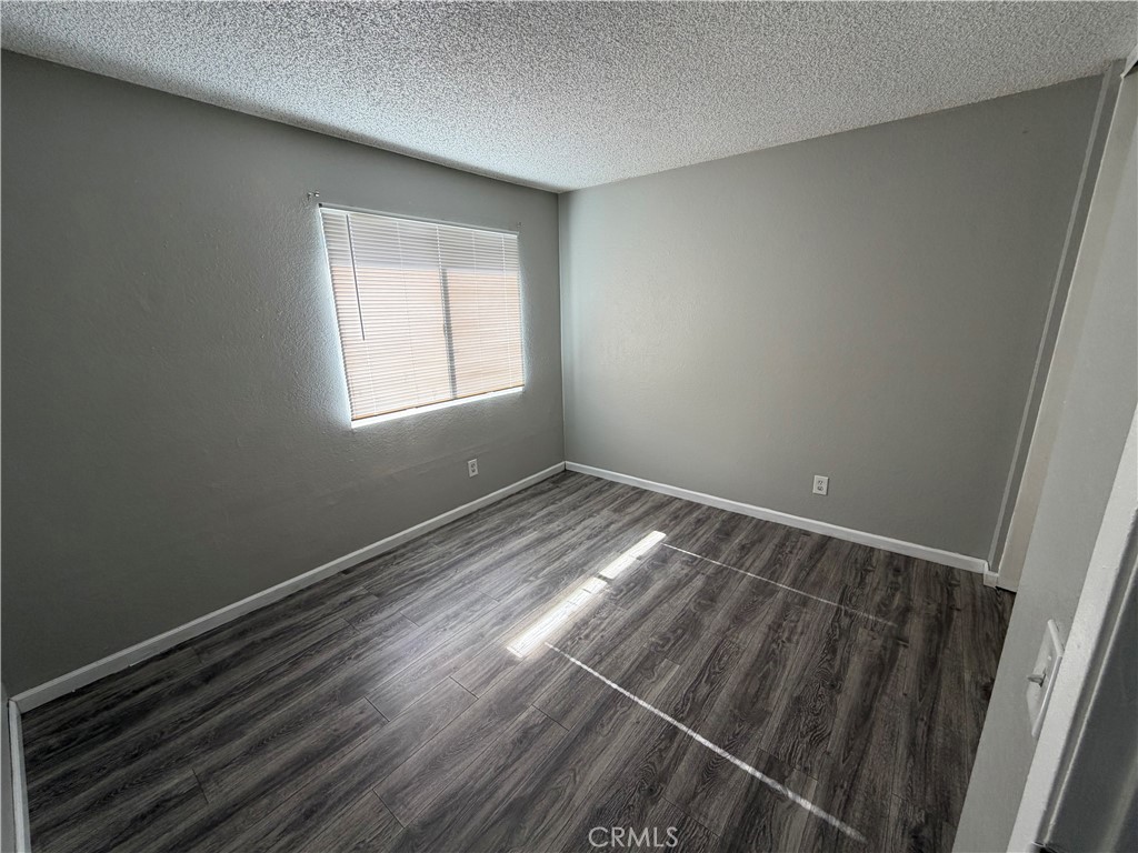 9240 Date Street, Unit 9F Fontana, CA 92335 - Photo 12 of 13 a view of an empty room with wooden floor and a window