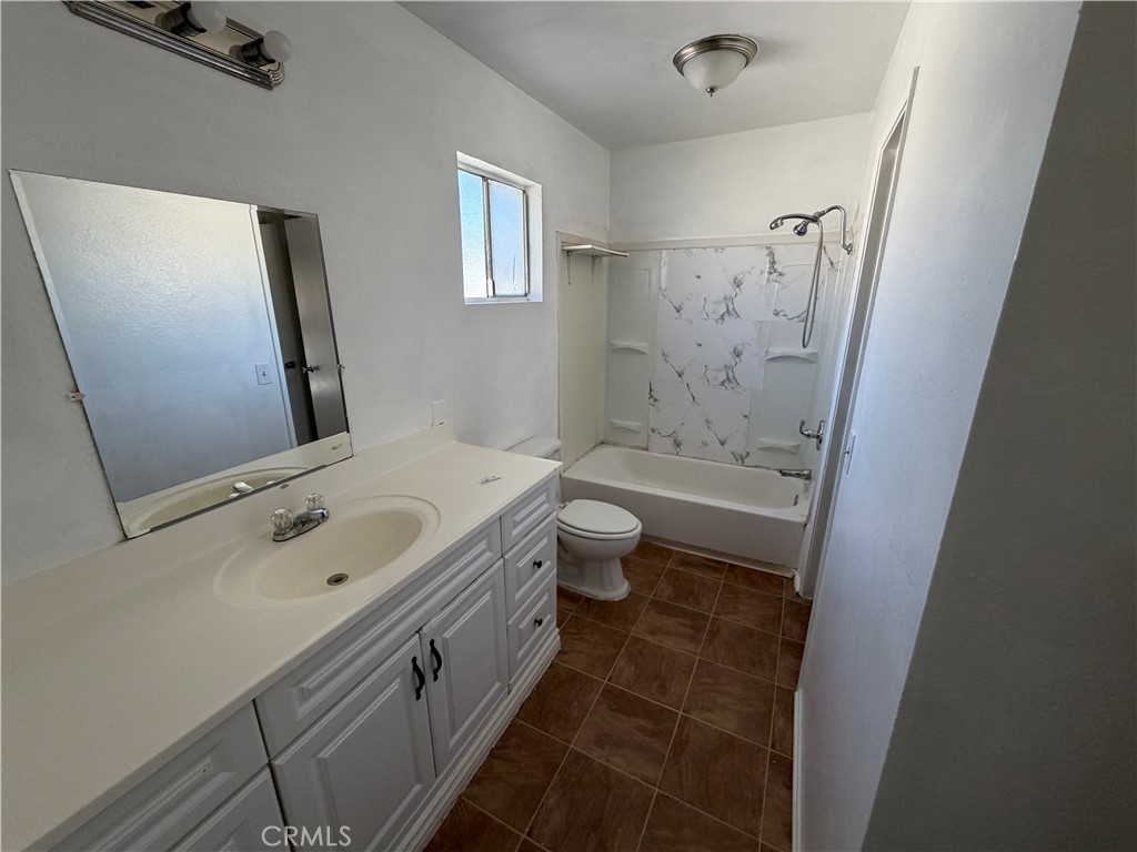 9240 Date Street, Unit 9F Fontana, CA 92335 - Photo 13 of 13 a bathroom with a granite countertop sink a toilet and shower