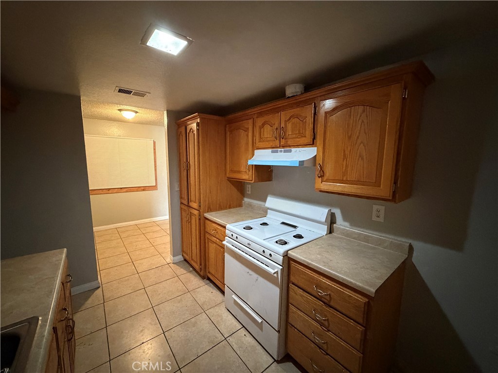 9240 Date Street, Unit 9F Fontana, CA 92335 - Photo 5 of 13 a kitchen with a stove a sink and a refrigerator