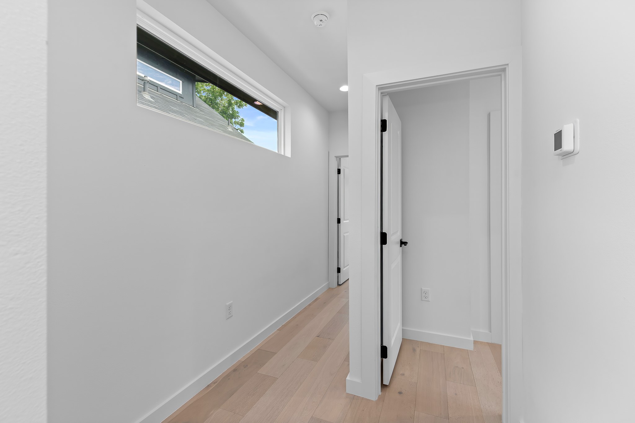 5305 Ledesma Road, Unit 4 Austin, TX 78721 - Photo 23 of 40 A well-lit hallway with natural wood flooring leads to bright, contemporary living spaces.