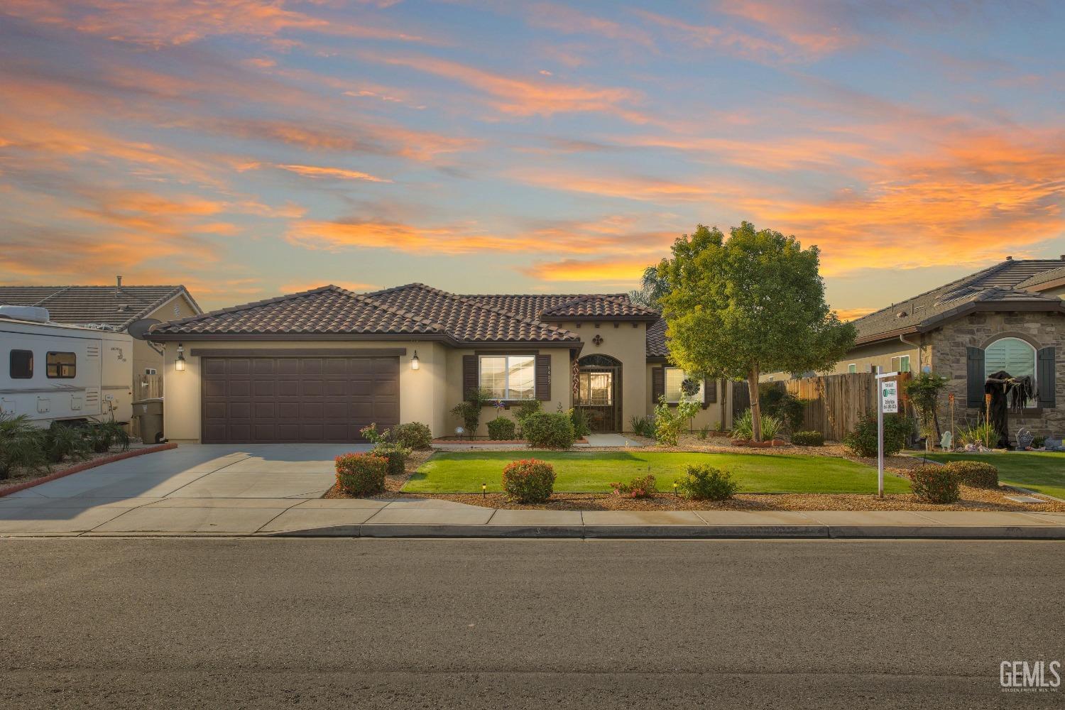 a front view of a house with a yard and trees