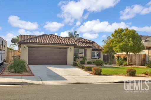 Undisclosed Address Bakersfield, CA 93311 - Photo 3 of 22 a front view of a house with a garden and garage
