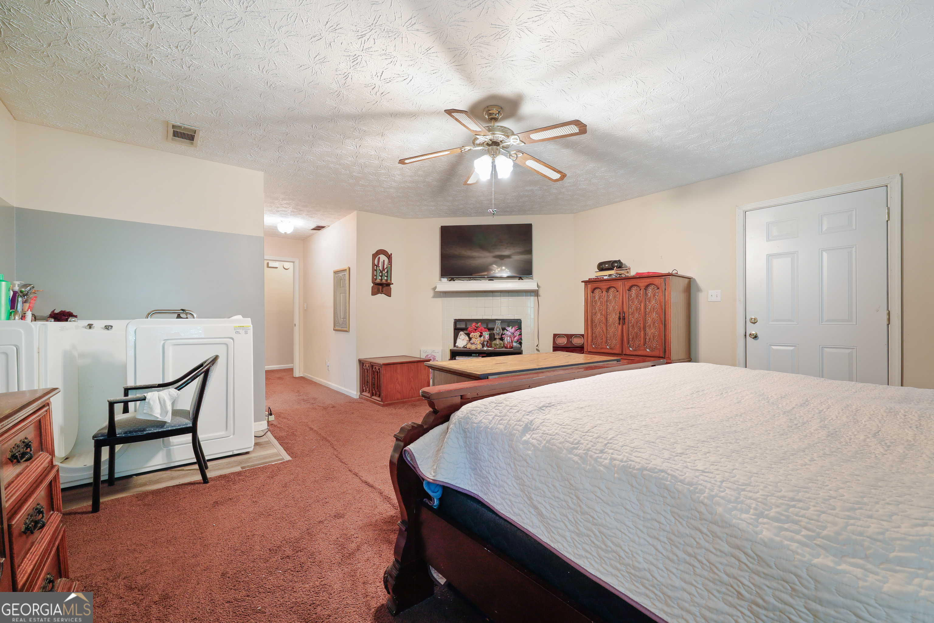 2433 Bear Creek Road Statham, GA 30666 - Photo 23 of 58 a spacious bedroom with a bed and a chandelier