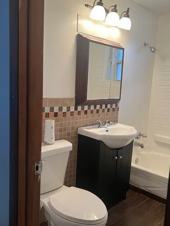 a bathroom with a sink vanity granite and toilet