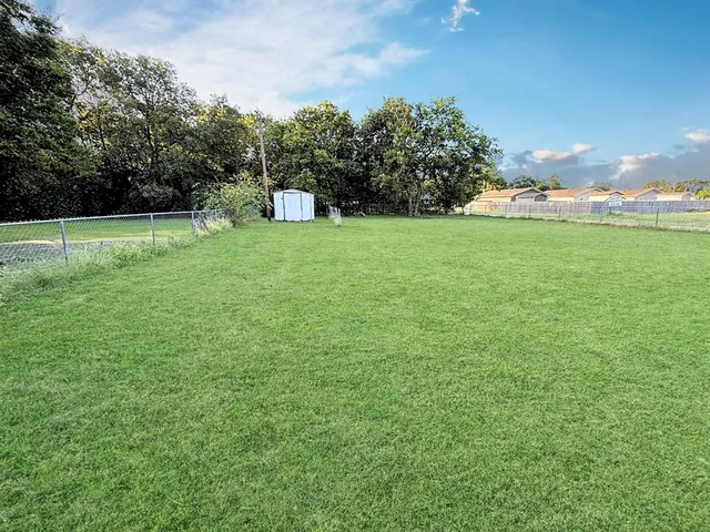 a view of a green field with wooden fence