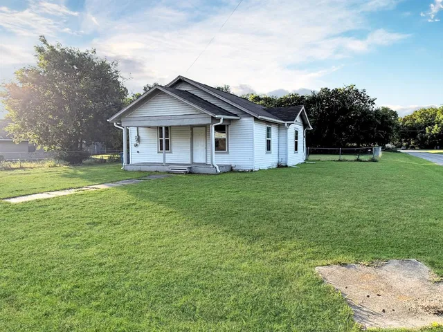 a view of a house with a big yard and large trees