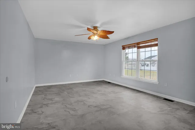 a view of a livingroom with a ceiling fan and window