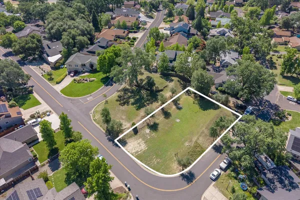 an aerial view of a house a yard and mountain