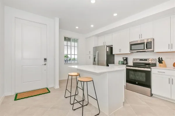 a kitchen with stainless steel appliances a stove a sink cabinets and a refrigerator
