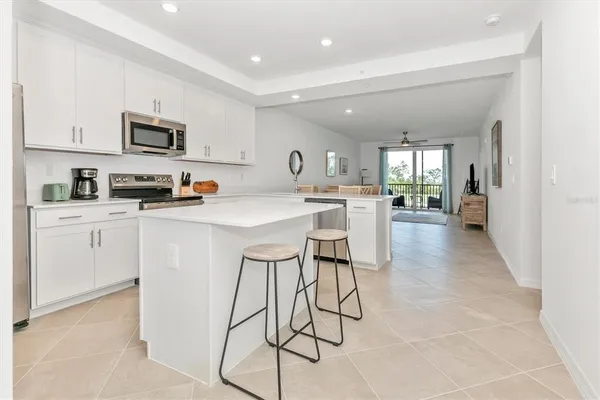 a kitchen with stainless steel appliances a sink a stove a refrigerator cabinets and a counter top space