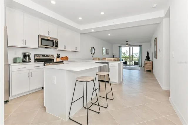 a kitchen with stainless steel appliances a sink a stove a refrigerator cabinets and a counter top space