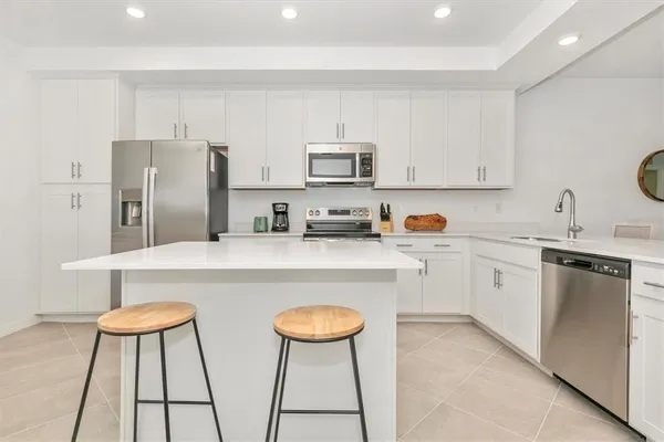 a kitchen with appliances a sink and cabinets