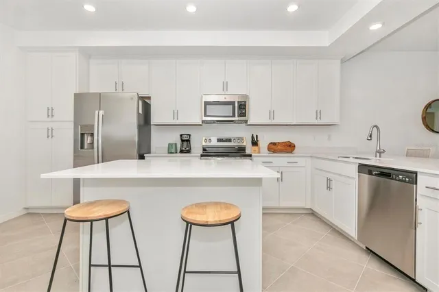 a kitchen with appliances a sink and cabinets