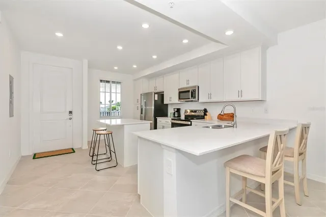 a kitchen with a dining table chairs and large window