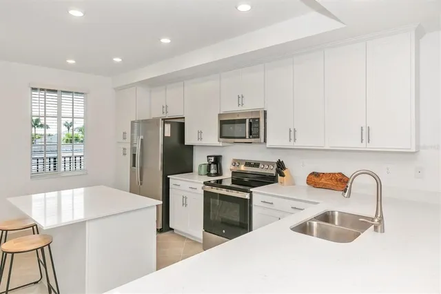 a living room with furniture and a view of kitchen