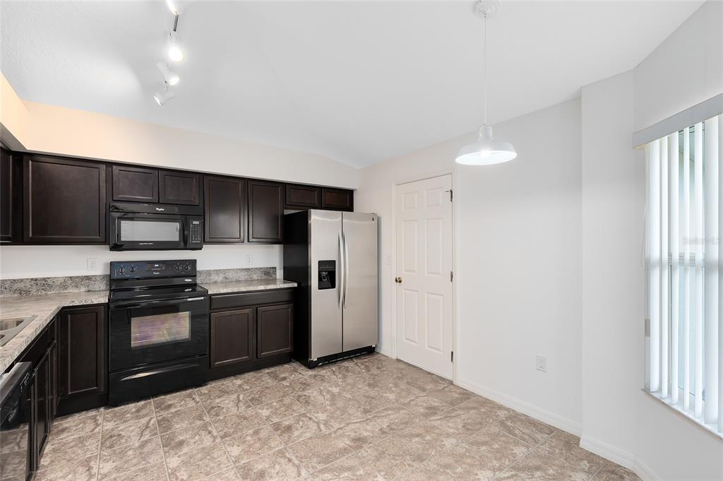 2717 Shelby Ruth Place St. Cloud, FL 34769 - Photo 9 of 31 a kitchen with stainless steel appliances granite countertop a stove a sink and a refrigerator