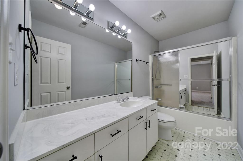 584 Cranborne Chase Fort Mill, SC 29708 - Photo 25 of 36 a bathroom with a granite countertop sink a toilet a mirror and shower