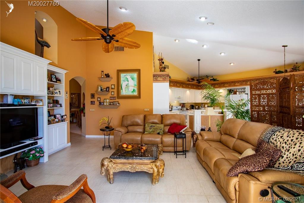 1946 Northwest Fork Road Stuart, FL 34994 - Photo 12 of 32 a living room with furniture a flat screen tv and a fireplace