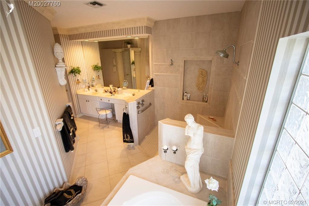 1946 Northwest Fork Road Stuart, FL 34994 - Photo 23 of 32 a bathroom with a sink a mirror and shower