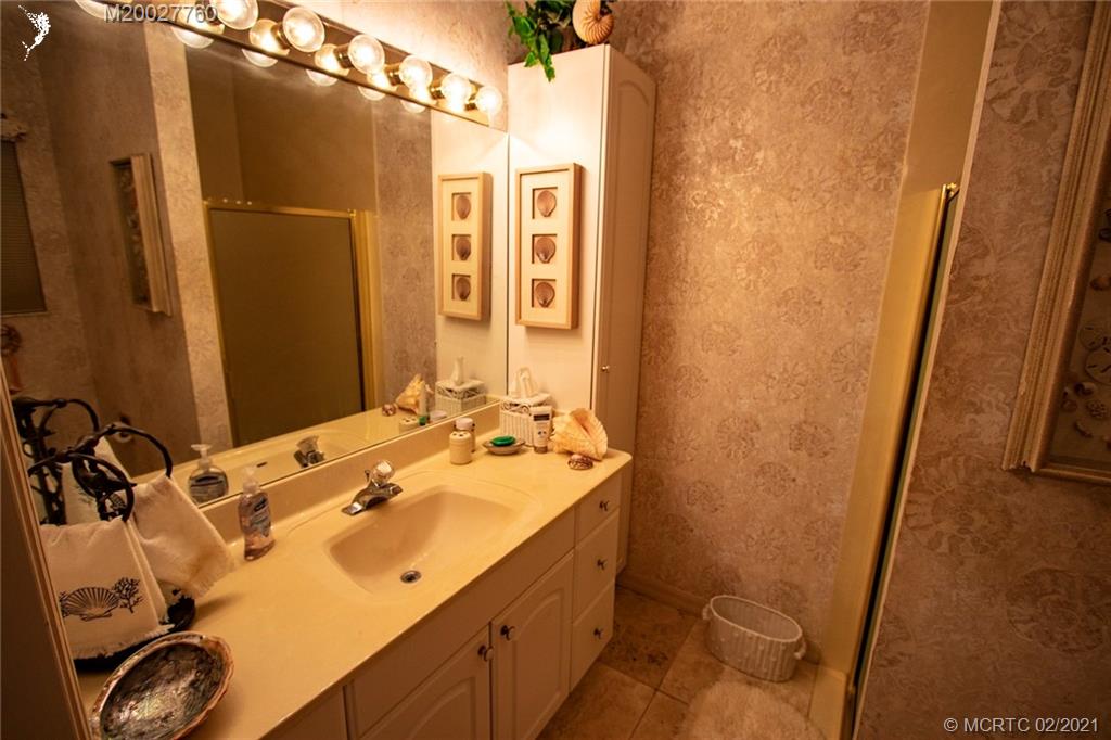 1946 Northwest Fork Road Stuart, FL 34994 - Photo 27 of 32 a bathroom with a sink and a mirror