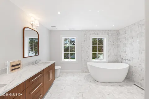 a spacious bathroom with a bathtub double sink and window