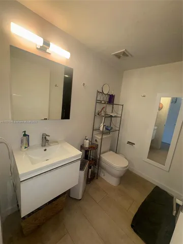 a bathroom with a sink mirror and toilet