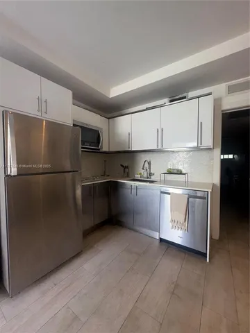 a kitchen with stainless steel appliances a refrigerator sink and cabinets