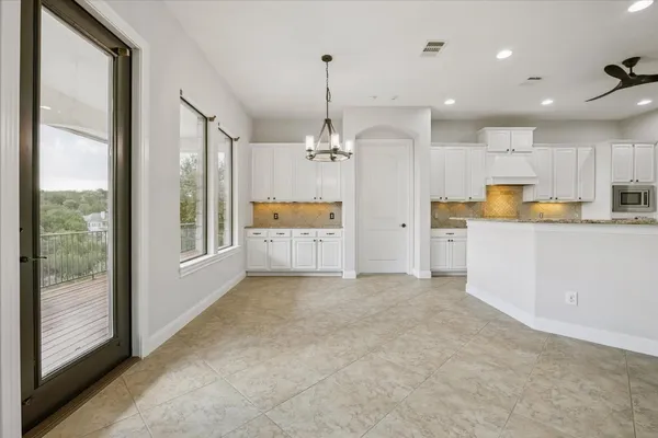 a view of a kitchen with large window and stainless steel appliances