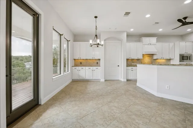 a view of a kitchen with large window and stainless steel appliances