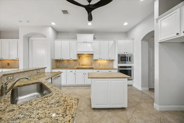a kitchen with a sink a stove a refrigerator and cabinets
