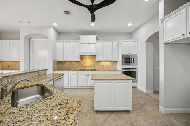 a kitchen with a sink a stove a refrigerator and cabinets