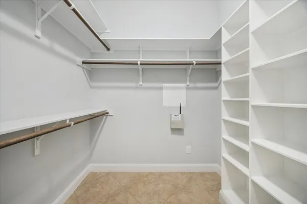 a view of walk in closet with empty racks