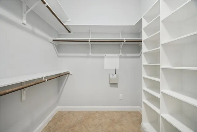 a view of walk in closet with empty racks