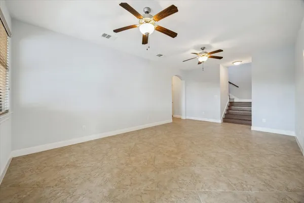 an empty room with a ceiling fan and a window