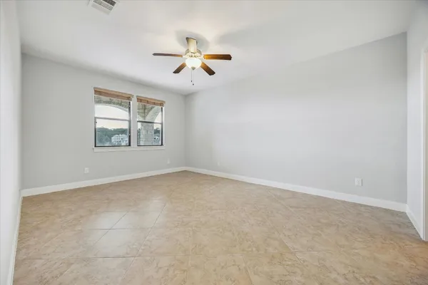 an empty room with windows and fan