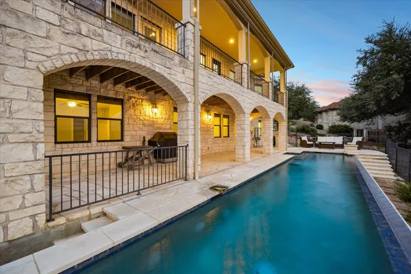 a view of a swimming pool with a patio and a yard