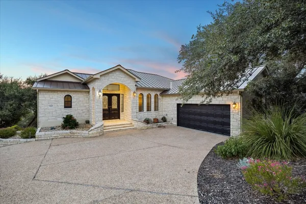 a front view of a house with a garden and yard