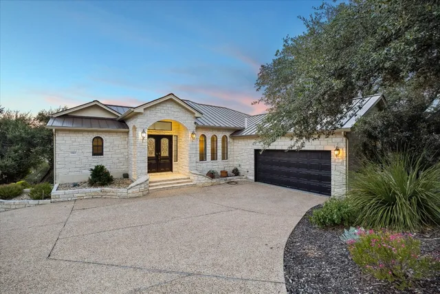 a front view of a house with a garden and yard