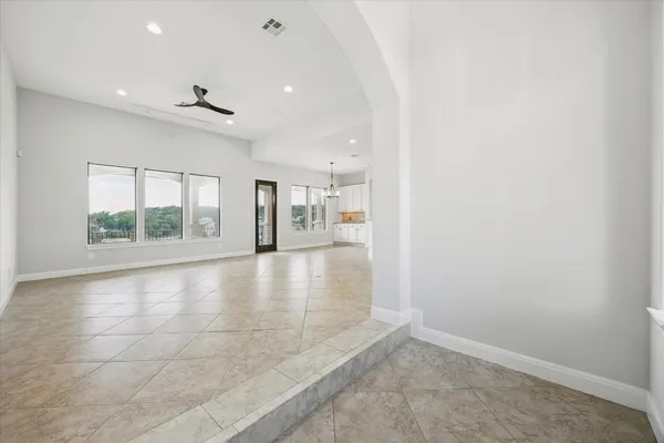 an empty room with large windows and chandelier