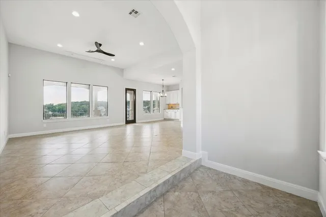 an empty room with large windows and chandelier