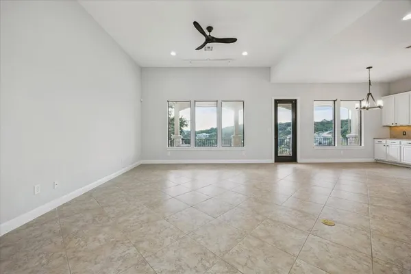 an empty room with windows and ceiling fan