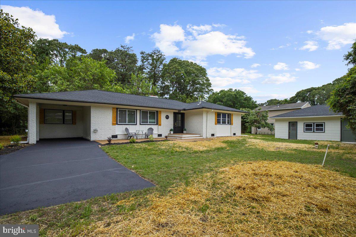 a front view of a house with a yard and trees