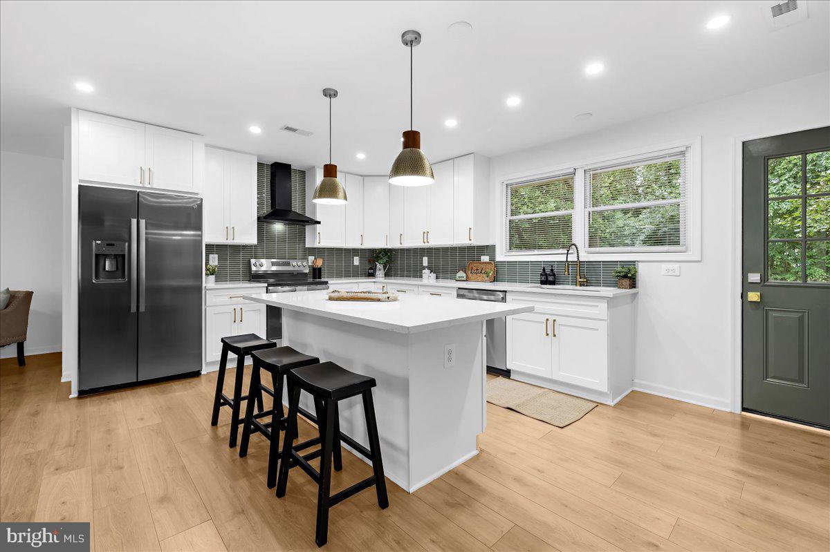 624 Sutton Drive Pasadena, MD 21122 - Photo 11 of 64 a kitchen with white cabinets a sink a window and stainless steel appliances