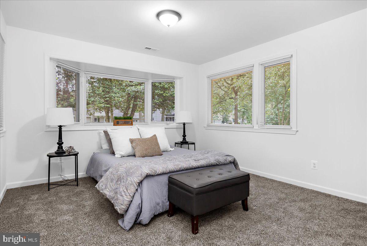 624 Sutton Drive Pasadena, MD 21122 - Photo 21 of 64 a bedroom with a bed lamp and a large window