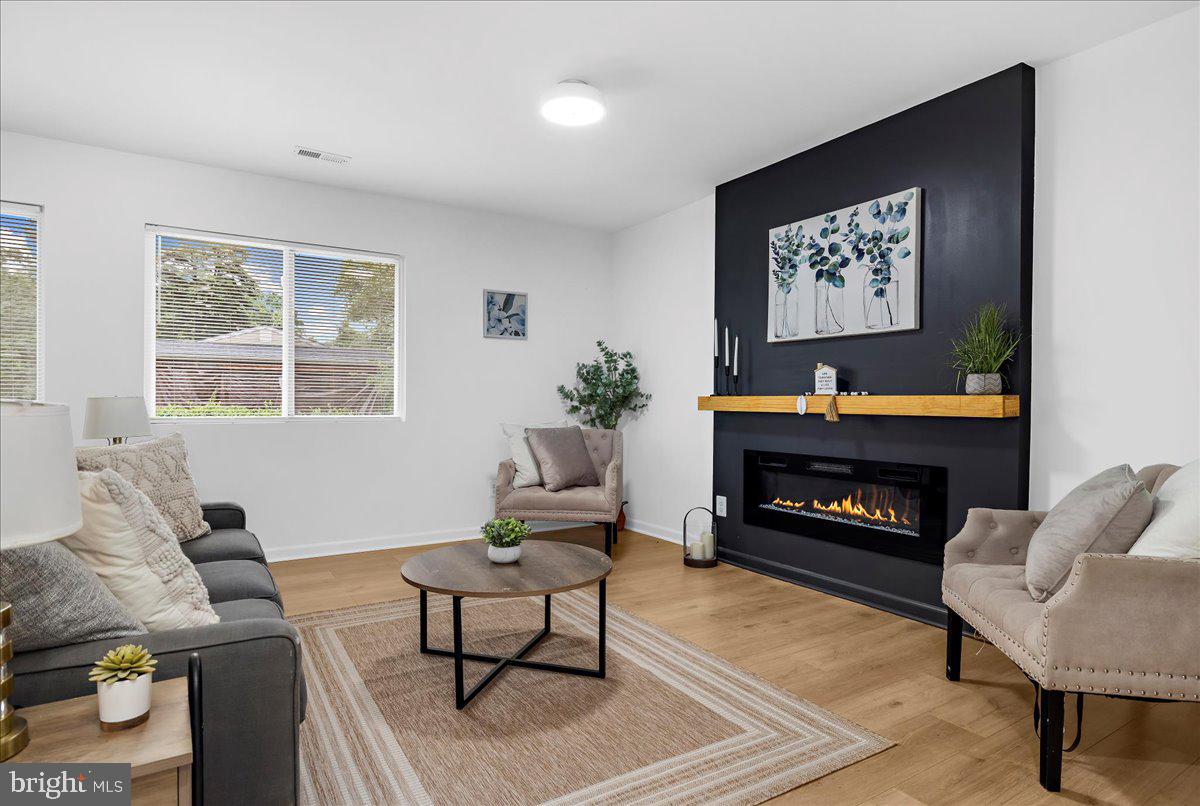 624 Sutton Drive Pasadena, MD 21122 - Photo 3 of 64 a living room with furniture a fireplace and a flat screen tv