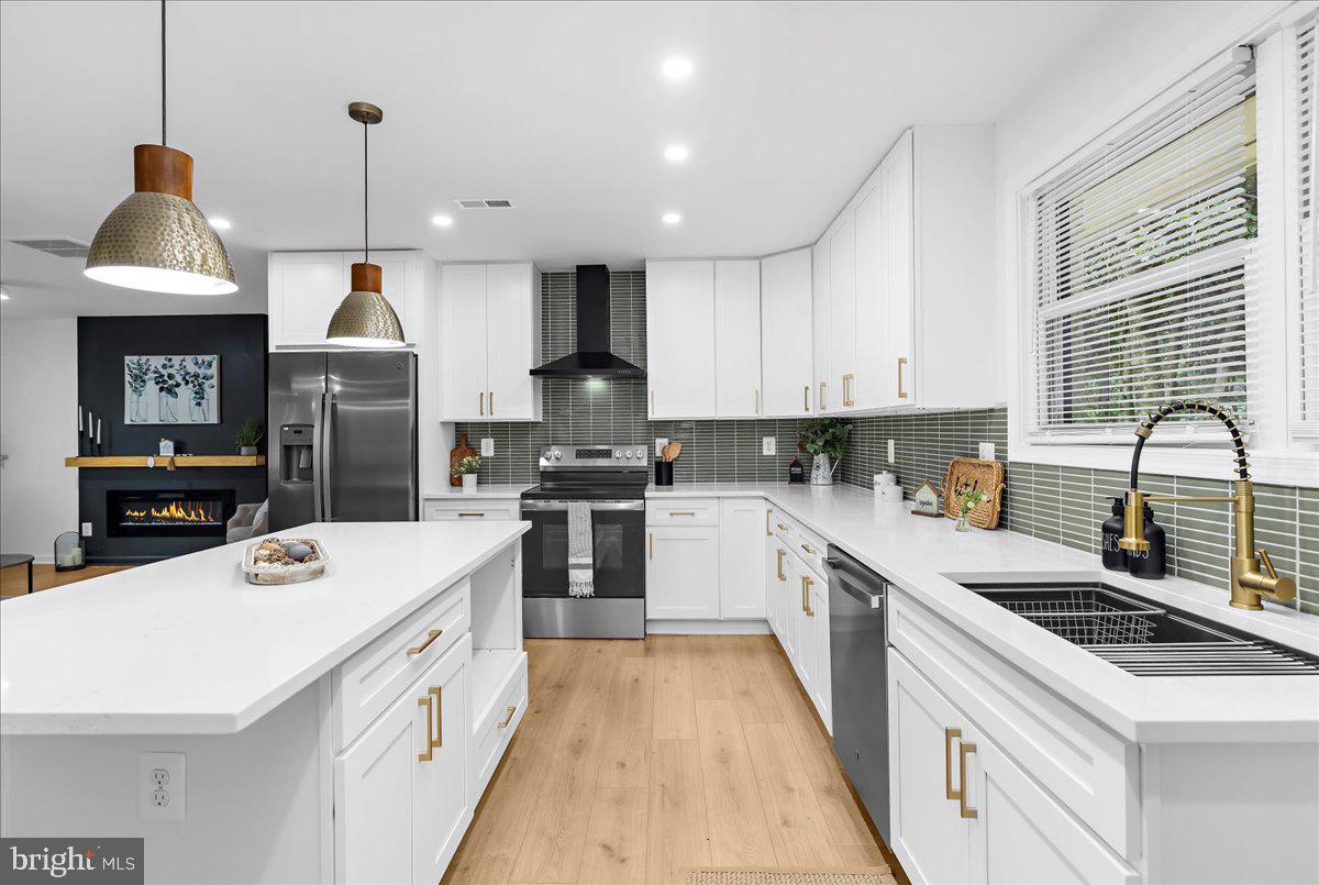 624 Sutton Drive Pasadena, MD 21122 - Photo 5 of 64 a kitchen with a sink a stove and cabinets